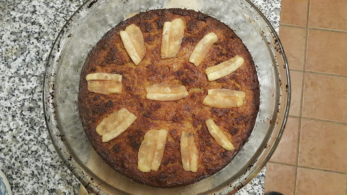 Cała babka ziemniaczana w okrągłym szklanym naczyniu, z ciemnobrązowym wierzchem i paskami boczku