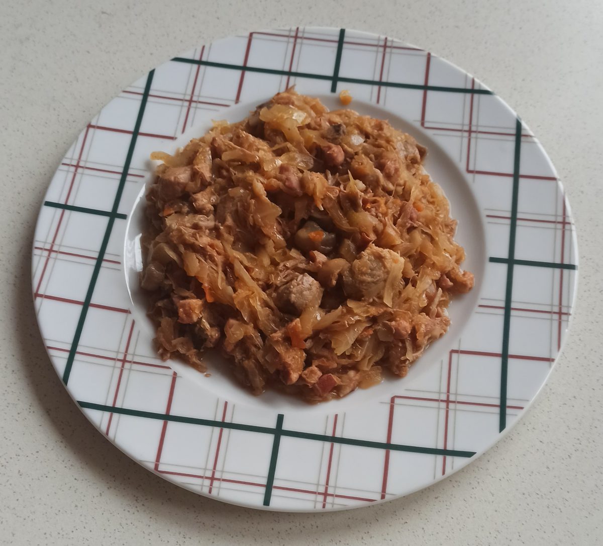 Porcja domowego bigosu na talerzu w kratkę