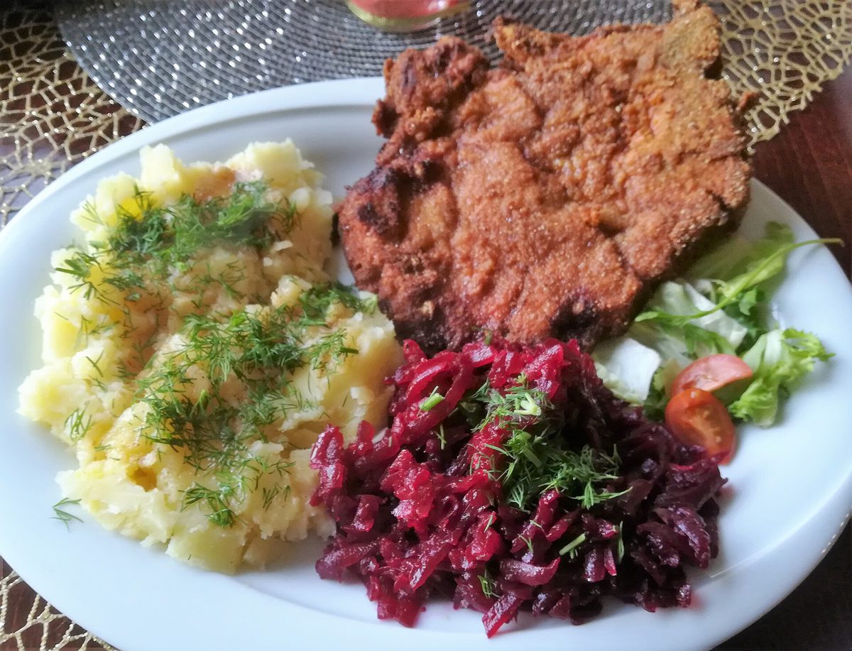 Kotlet panierowany, ziemniaki z koperkiem i buraczki na talerzu