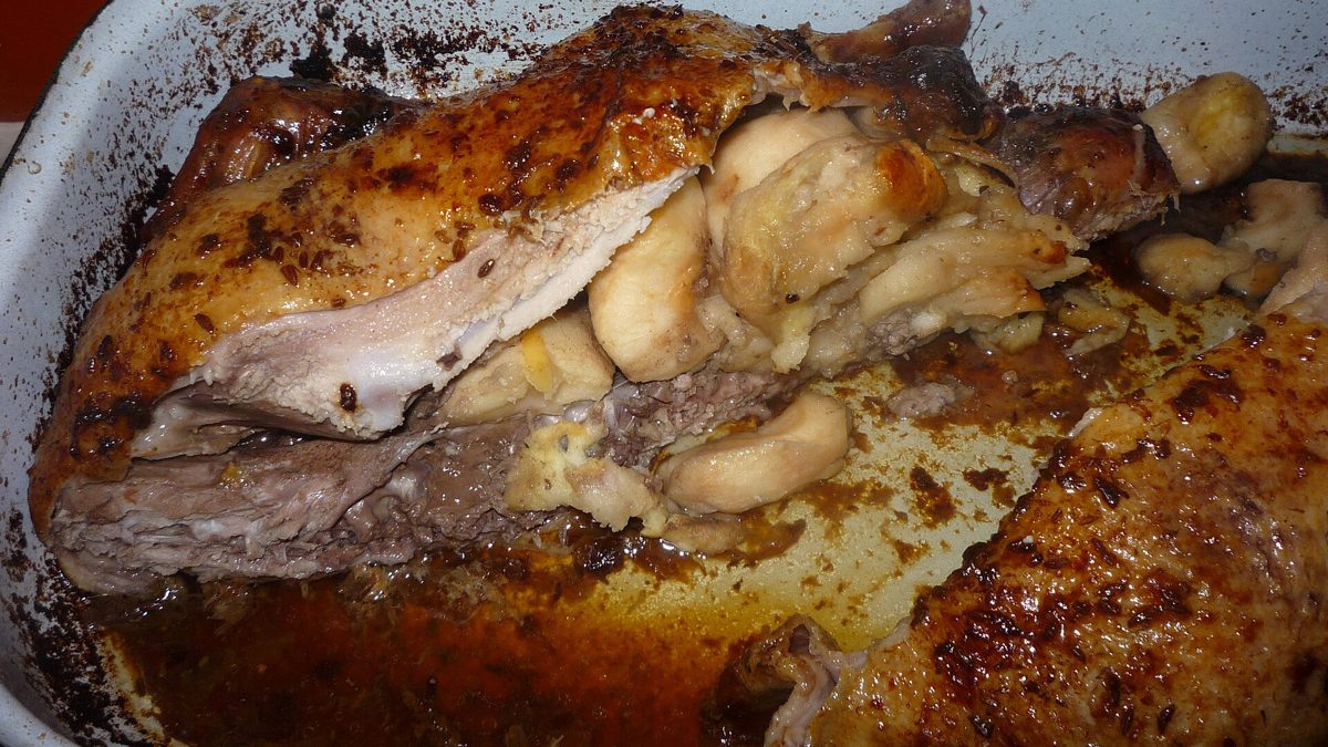 Przekrojona pieczona kaczka z miękkimi, upieczonymi jabłkami w środku