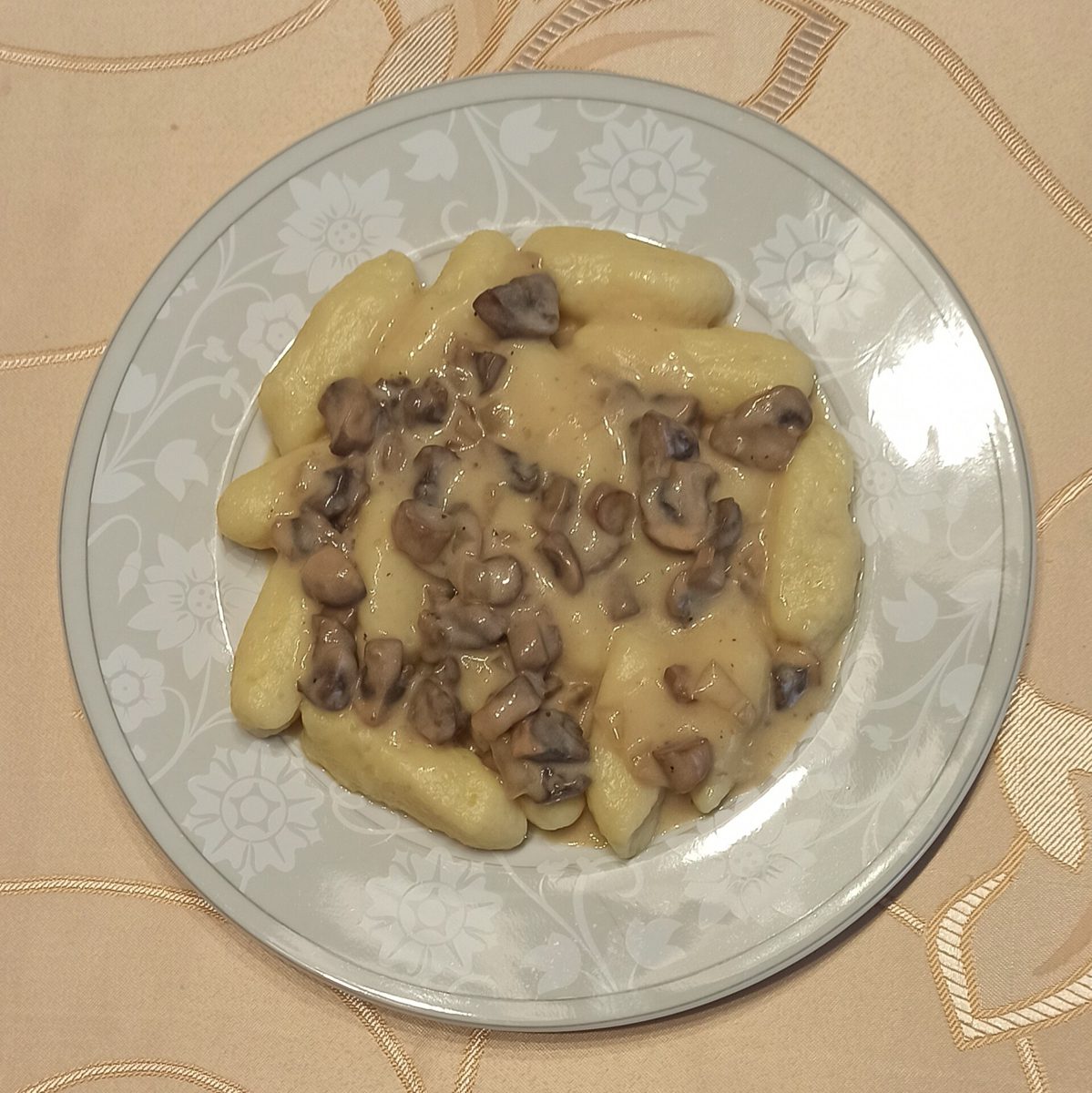 Kopytka z sosem pieczarkowym na talerzu