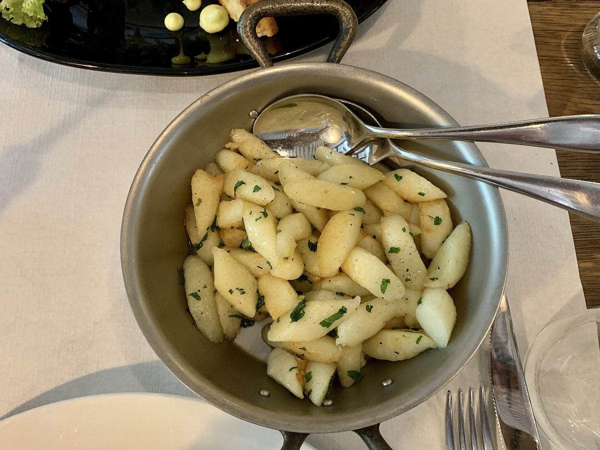 Kopytka z posiekanymi ziołami podane na małej patelni w krakowskiej restauracji