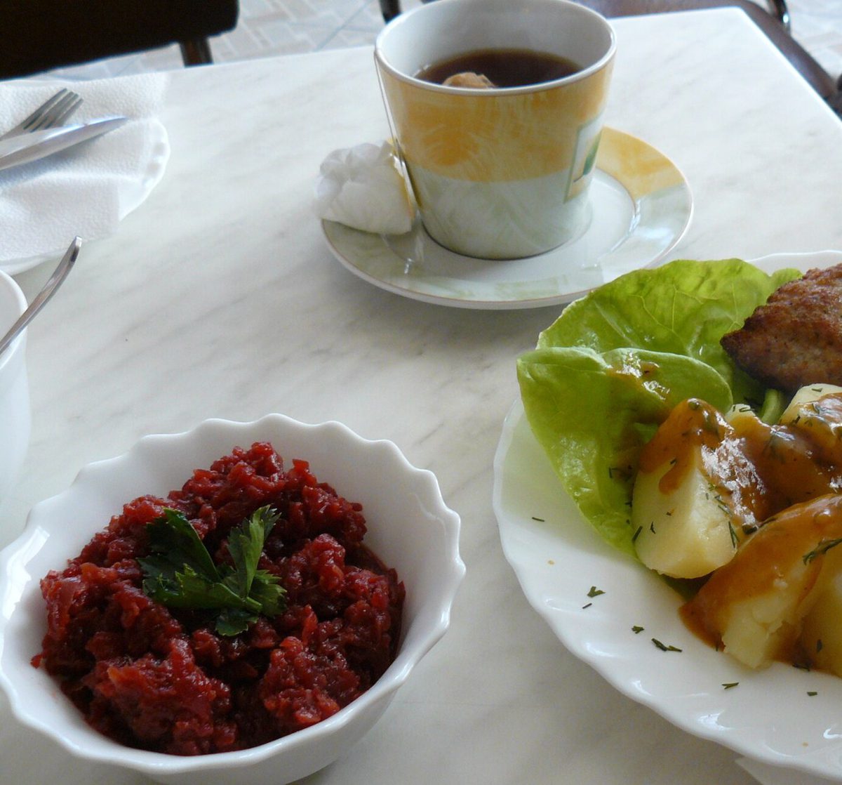 Kotlety mielone z ziemniakami w sosie, sałatą i miseczką buraczków