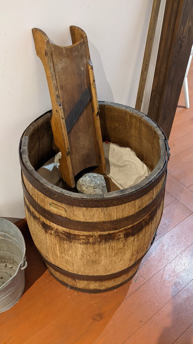 Dawna drewniana beczka do kiszenia kapusty z szatkownicą i kamieniem do obciążania, w Muzeum Bambrów Poznańskich