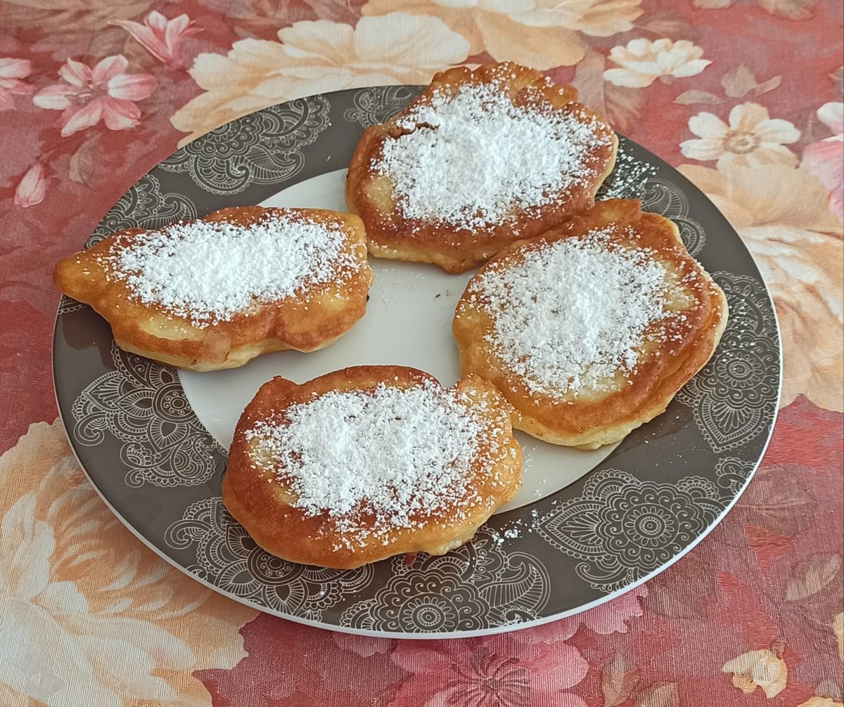 Cztery puszyste racuchy z grubą warstwą cukru pudru