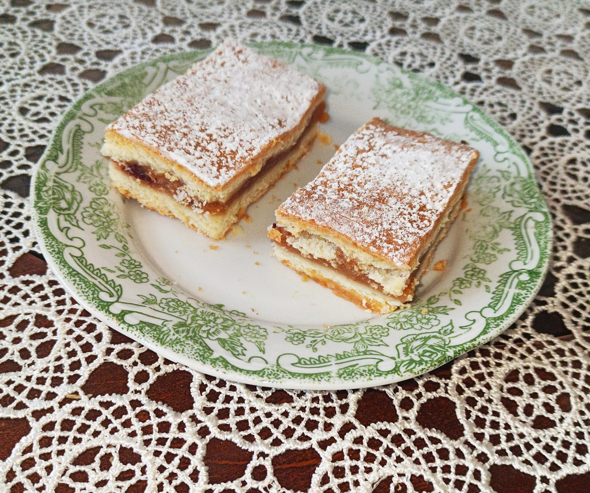 Dwa kawałki domowego jabłecznika posypane cukrem pudrem