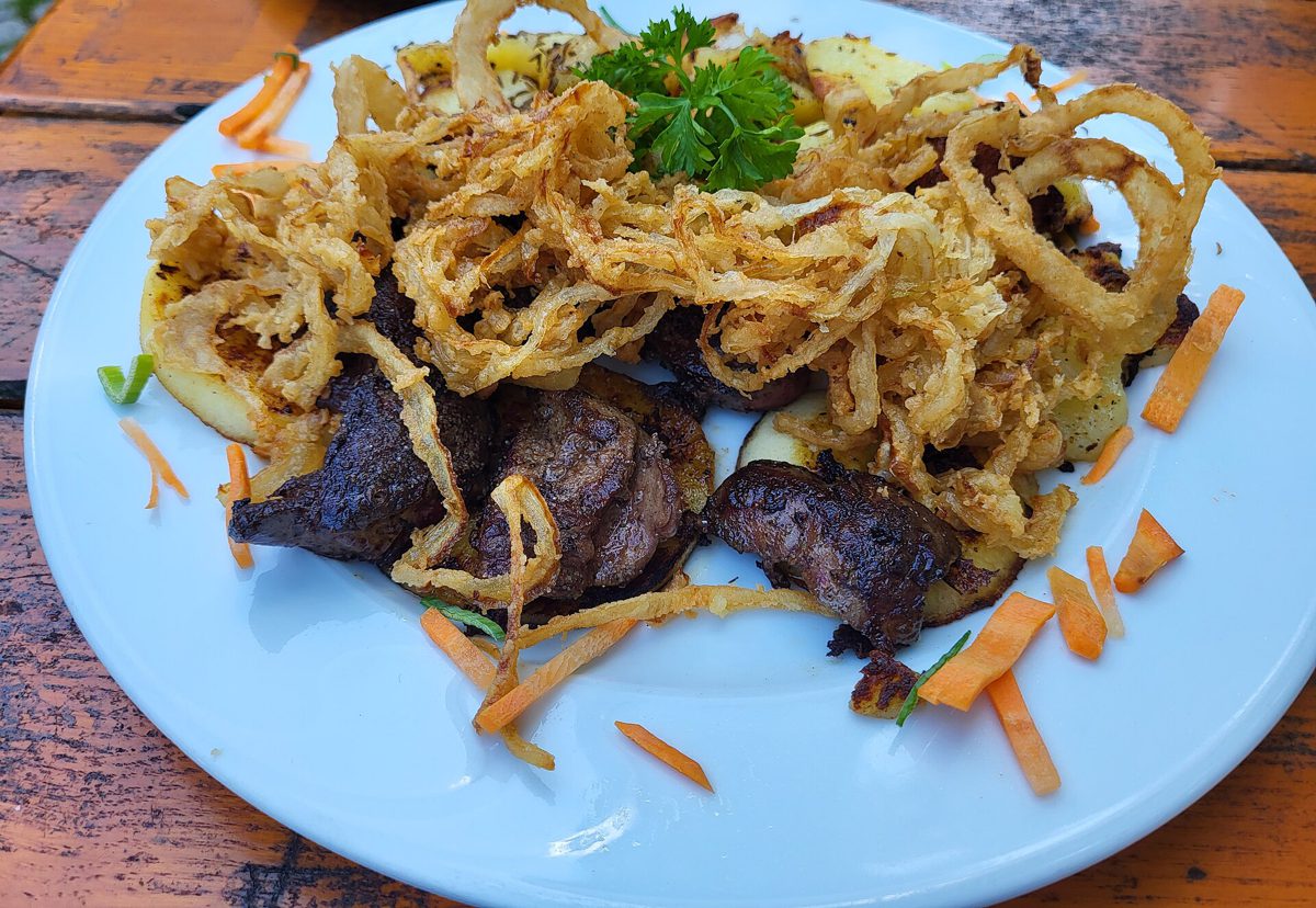 Smażona wątróbka drobiowa z plastrami jabłka i chrupiącą cebulą, podana w restauracji w Niemczech