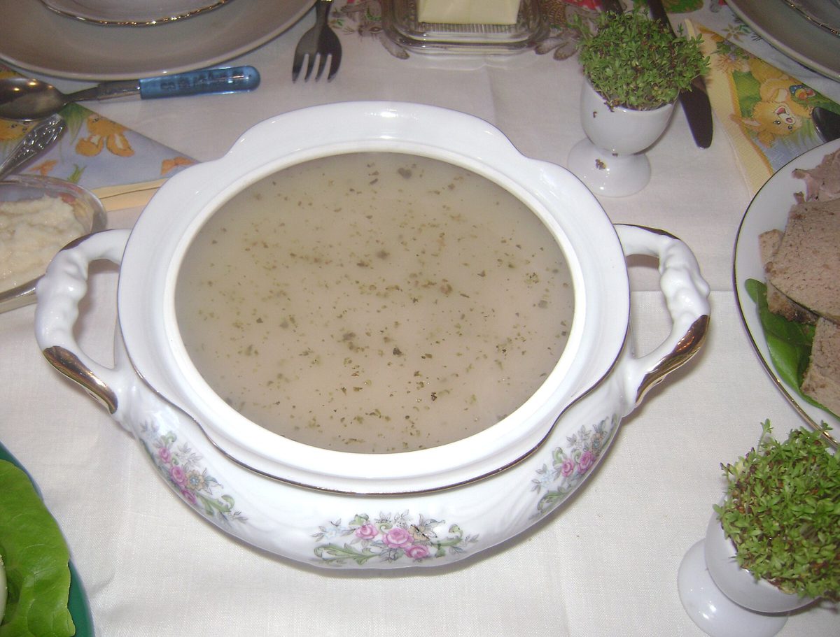 Żurek w porcelanowej wazie na wielkanocnym stole z rzeżuchą